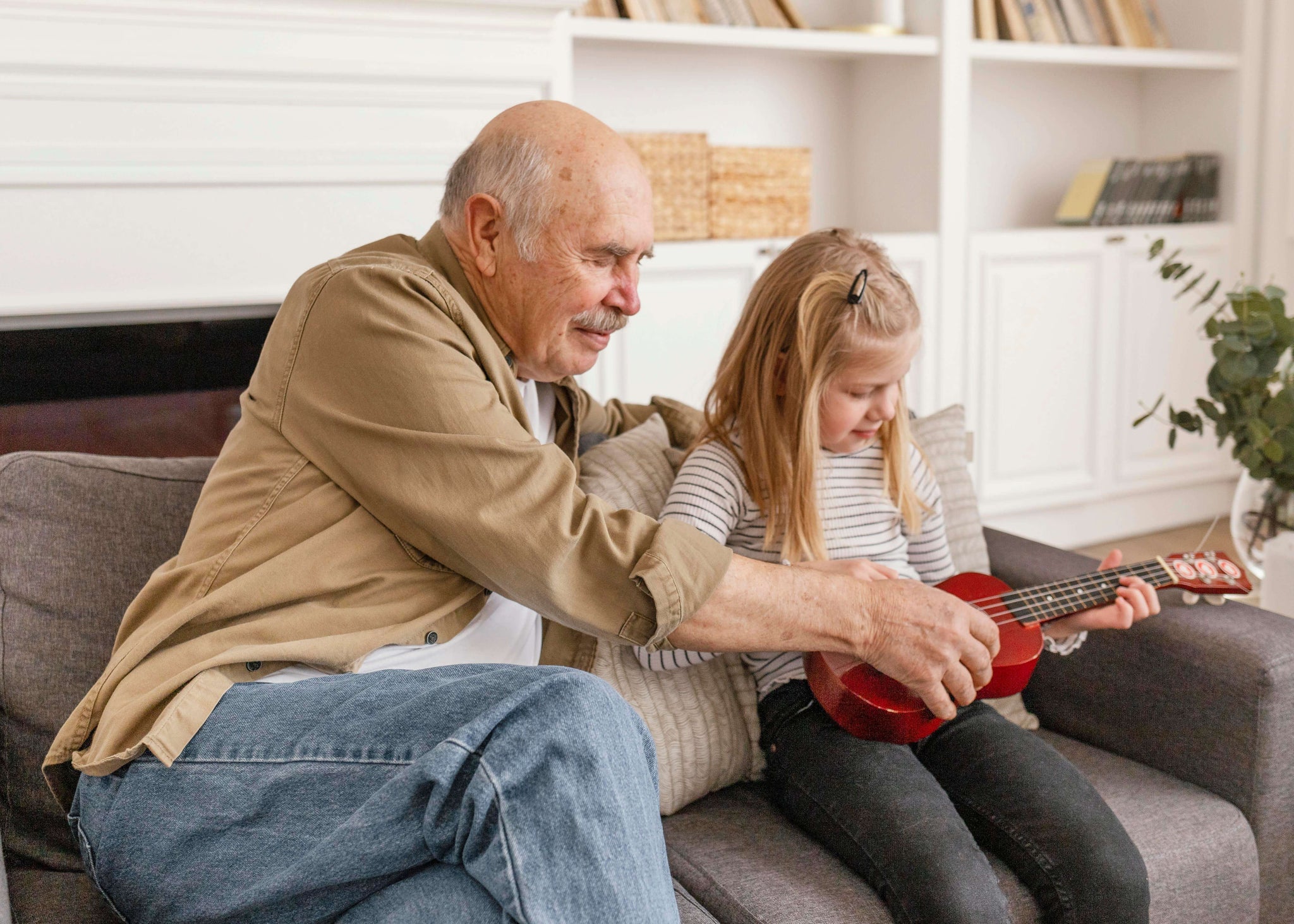Grandfather is playing with his little granddaughter